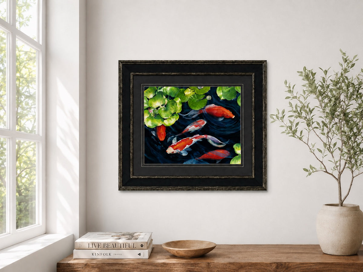 Coy Koi original watercolor shown framed in a modern interior above a wood cabinet with books and natural light.