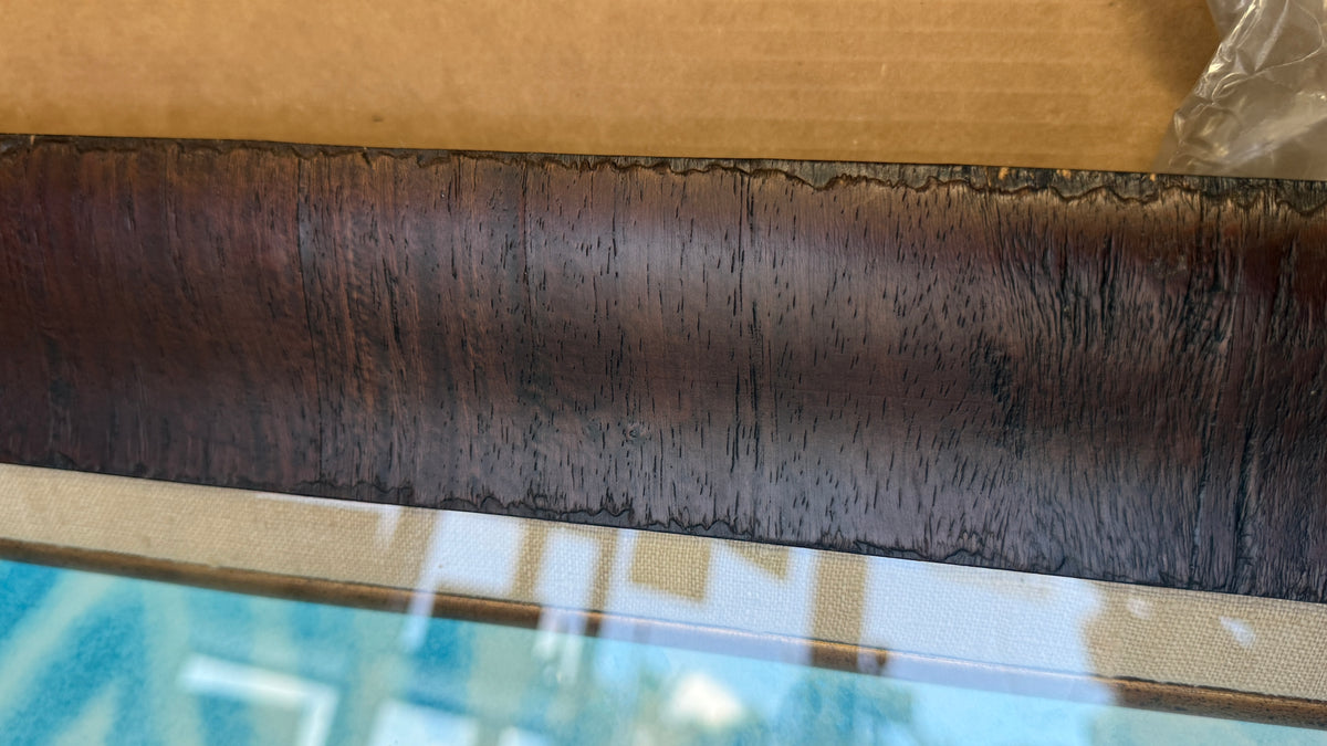 
Detail of Nani Honu professional framing showing warm dark wood grain and light taupe woven fabric liner